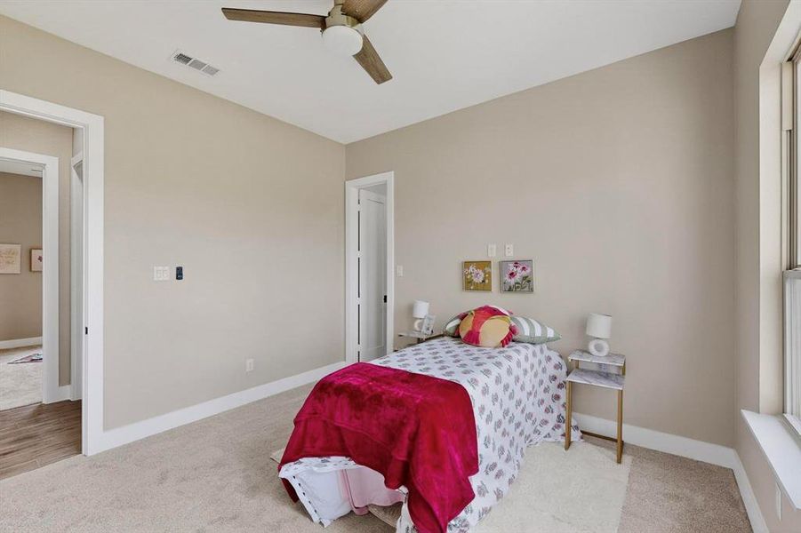Carpeted bedroom with baseboards and ceiling fan