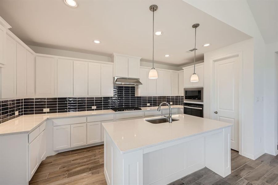 Kitchen with extractor fan, light hardwood / wood-style flooring, sink, white cabinetry, and appliances with stainless steel finishes