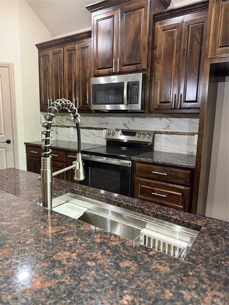 Kitchen featuring single basin, workstation Kitchen Sink All-in-One, with granite countertops and knotty alder cabinetry throughout Kitchen featuring single basin, workstation Kitchen Sink All-in-One, with granite countertops and knotty alder cabinetry throughout