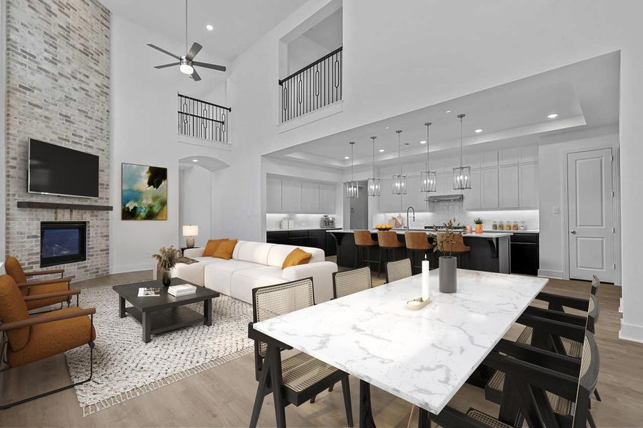 Dining area with ceiling fan, a fireplace, arched walkways, a high ceiling, and light wood finished floors Dining area with ceiling fan, a fireplace, arched walkways, a high ceiling, and light wood finished floors