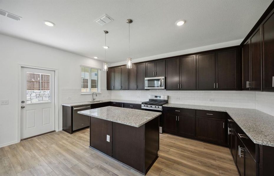 Spacious kitchen with oversized island *real home pictured