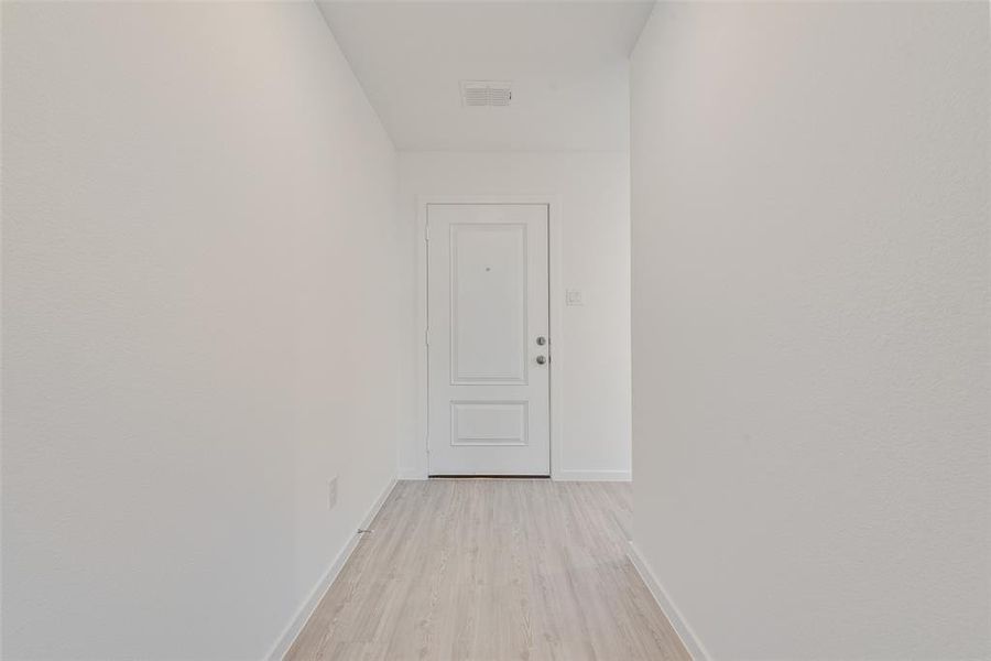 Hall with light hardwood / wood-style flooring