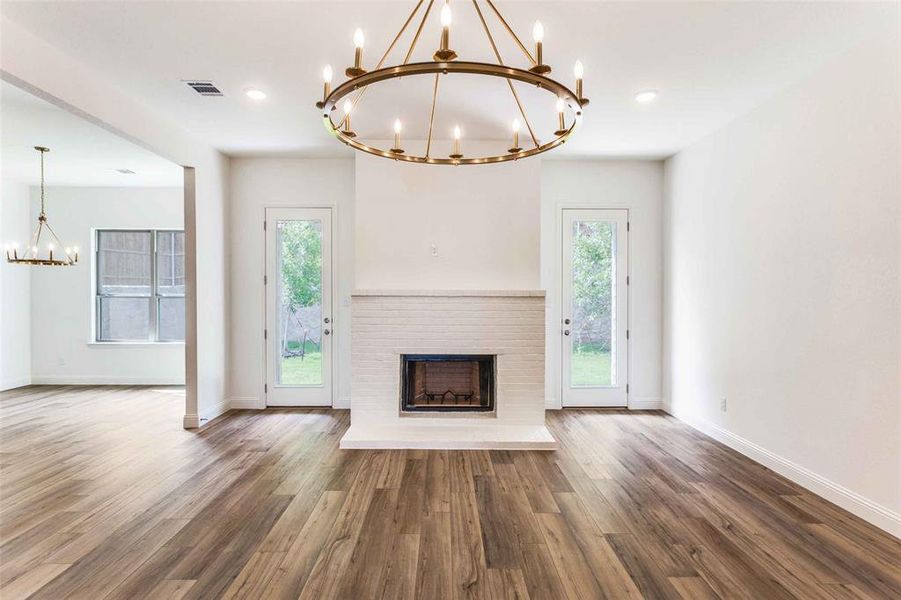 Unfurnished living room with a chandelier, plenty of natural light, baseboards, and recessed lighting Unfurnished living room with a chandelier, plenty of natural light, baseboards, and recessed lighting