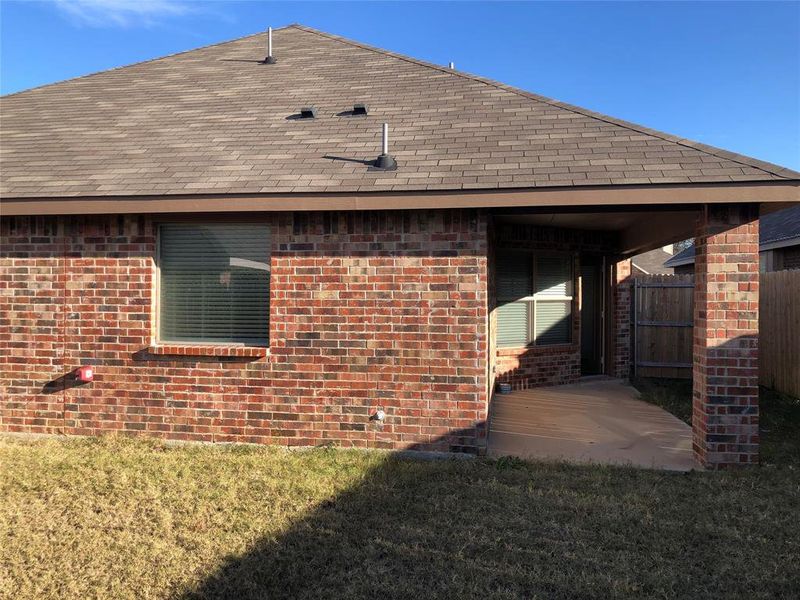 Rear view of house with a lawn and a patio