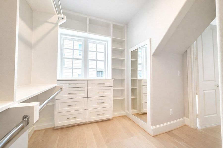 Primary closet (1 of 2) features custom built-ins.