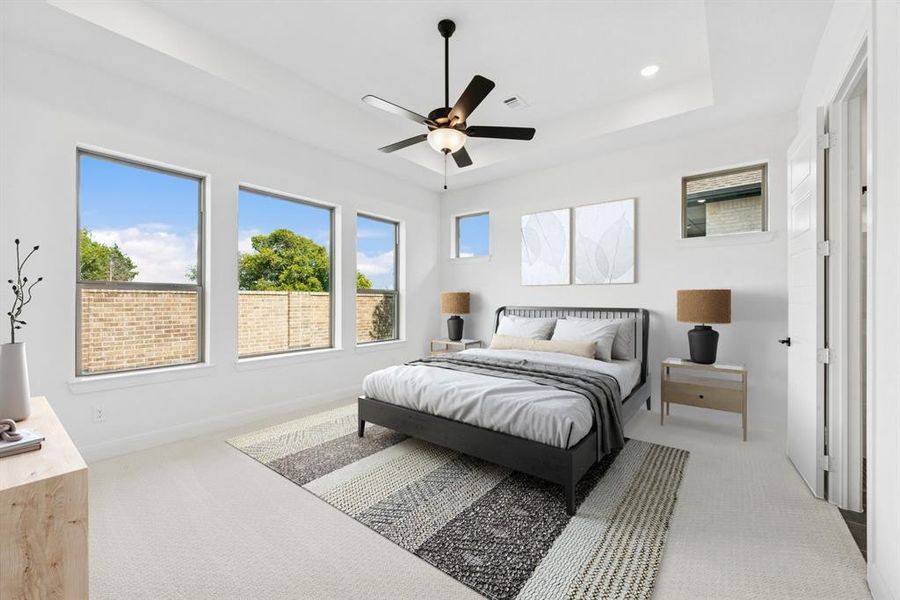 Bedroom with light carpet, ceiling fan, recessed lighting, and a raised ceiling Bedroom with light carpet, ceiling fan, recessed lighting, and a raised ceiling