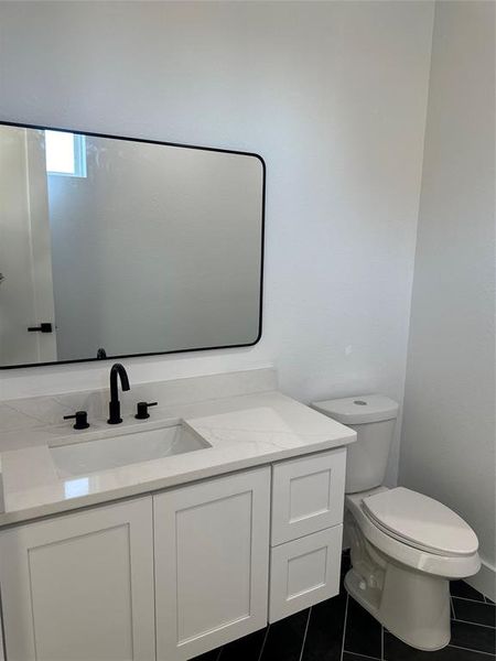 Bathroom with tile patterned flooring, vanity, and toilet