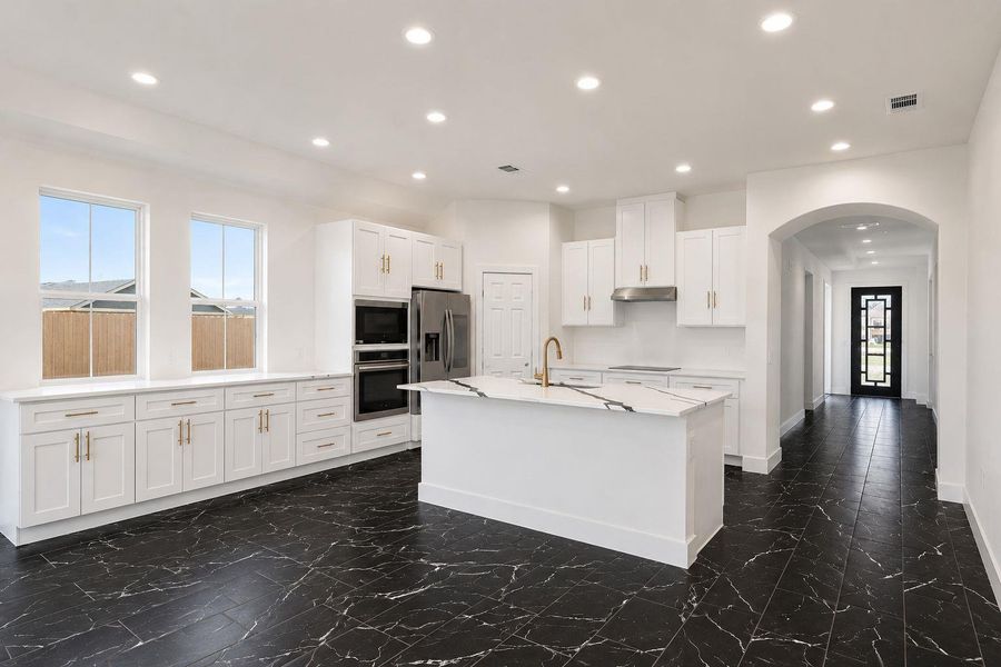 A well-appointed kitchen showcasing white cabinetry and a striking dark tile floor.