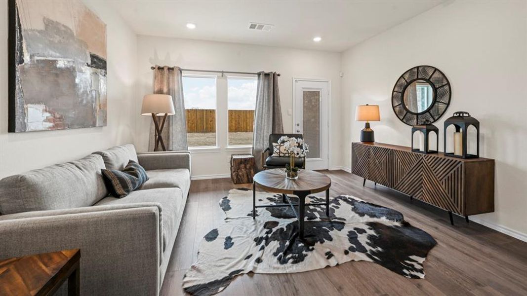 Spacious living area featuring wood-finish flooring, recessed lighting, and a neutral color palette