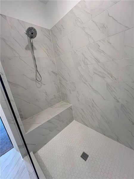 Owners Full bath featuring a tile shower and frameless shower door