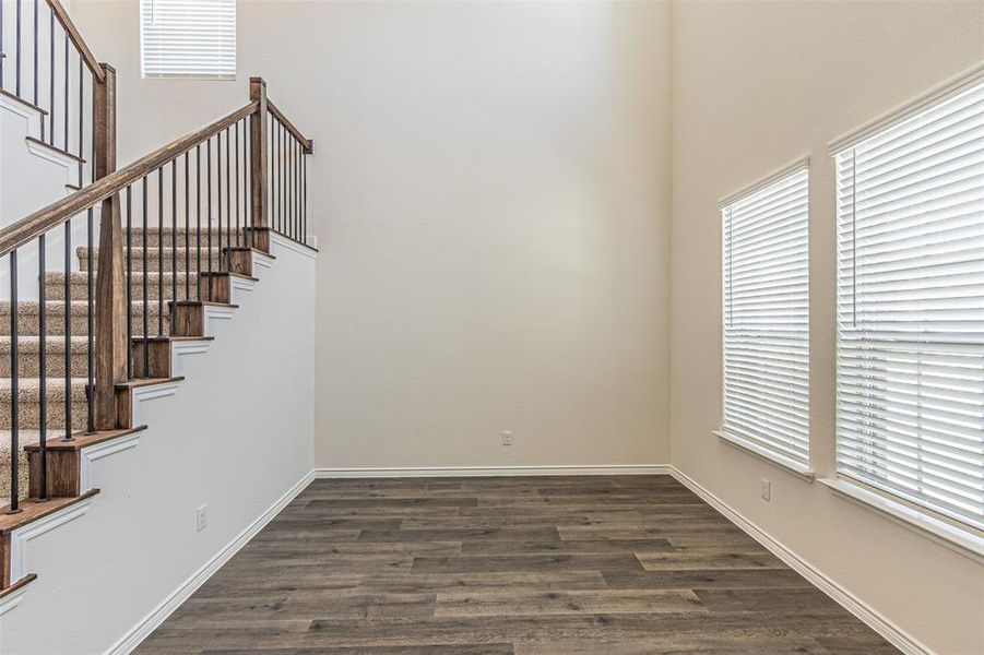 Staircase with hardwood / wood-style flooring and a high ceiling