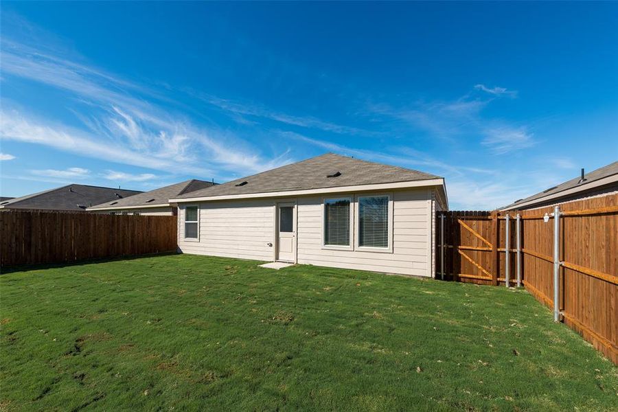 Back of house featuring a yard