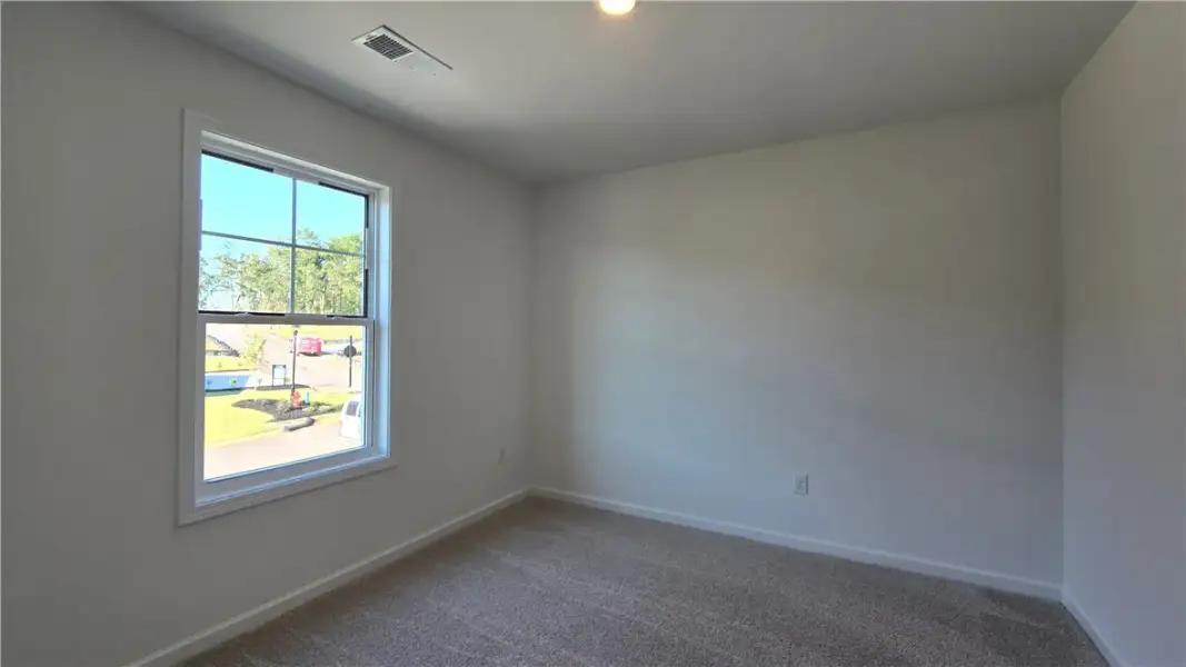 A quiet bedroom offers soft carpeting and a window