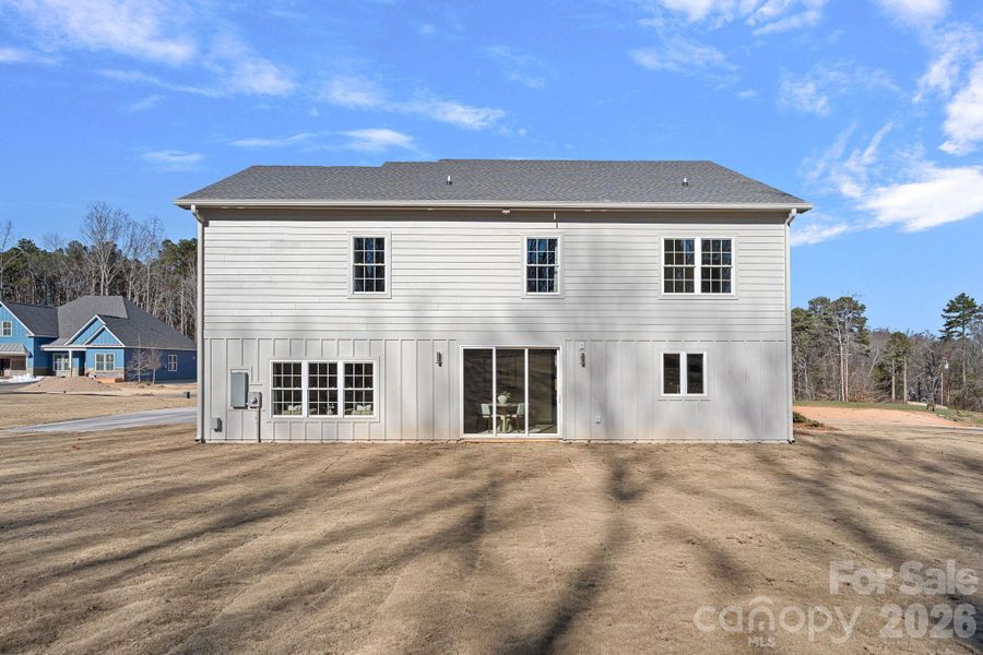 500w floodlight illuminating the grassy large backyard abutting old oak and pine trees.