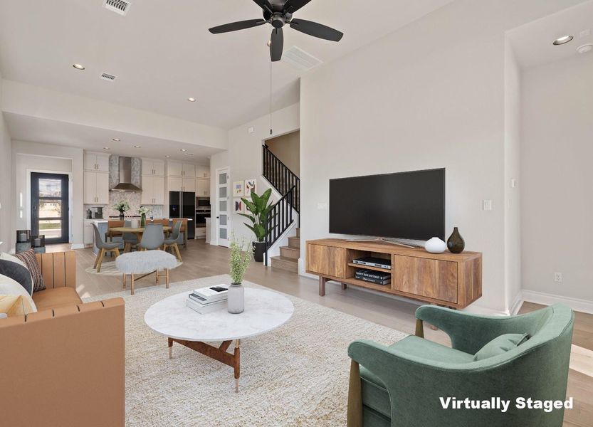 Living room with ceiling fan, light wood-type flooring, baseboards, and stairs Living room with ceiling fan, light wood-type flooring, baseboards, and stairs