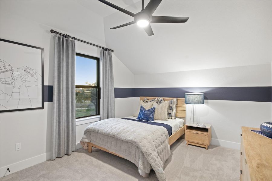 Carpeted bedroom featuring vaulted ceiling and a ceiling fan
