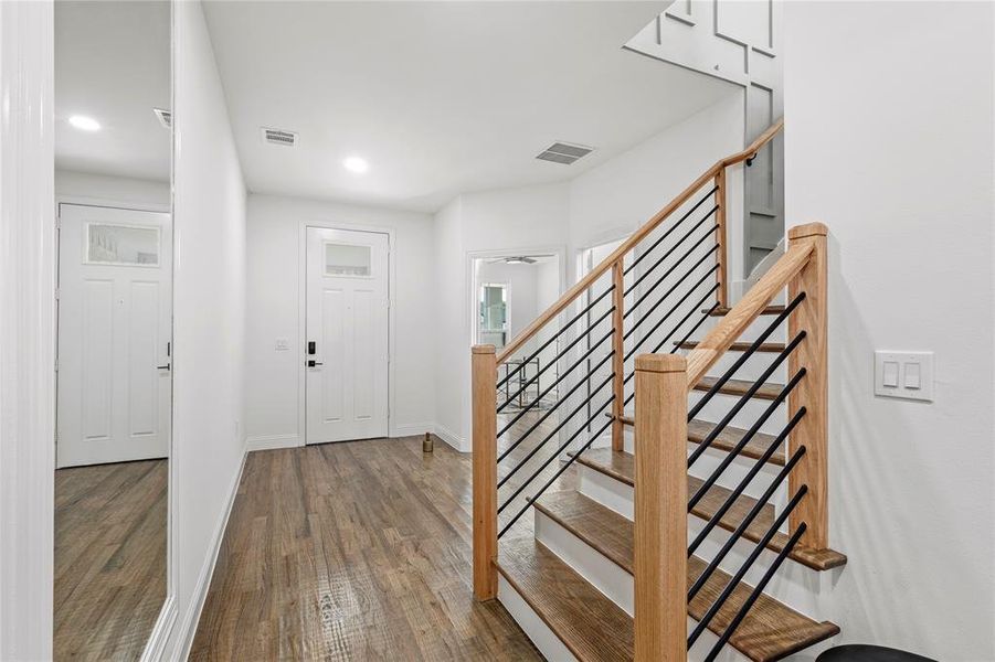 Foyer entrance featuring wood finished floors, stairway, and recessed lighting
