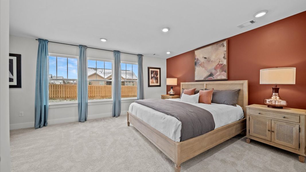 Vibrant natural light fills this exceptional primary bedroom with eye-catching details