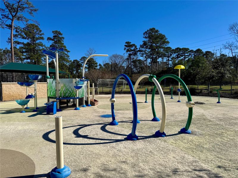 Vibrant splash pad in a park setting, surrounded by tall trees and clear skies. It offers a fun and inviting play area for children, with various colorful water features and structures. Vibrant splash pad in a park setting, surrounded by tall trees and clear skies. It offers a fun and inviting play area for children, with various colorful water features and structures.