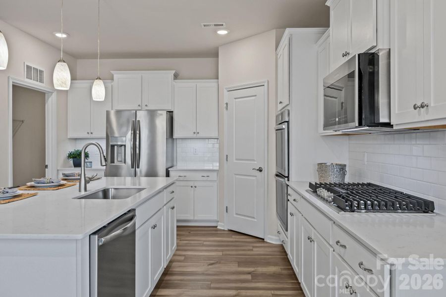 Lots of room to work and play! Thoughtfully designed with large stainless sink and pulldown sprayer near the island diswasher.  This is the GOURMET UPGRADED PACKAGE.  Notice the custom built-in gas range!