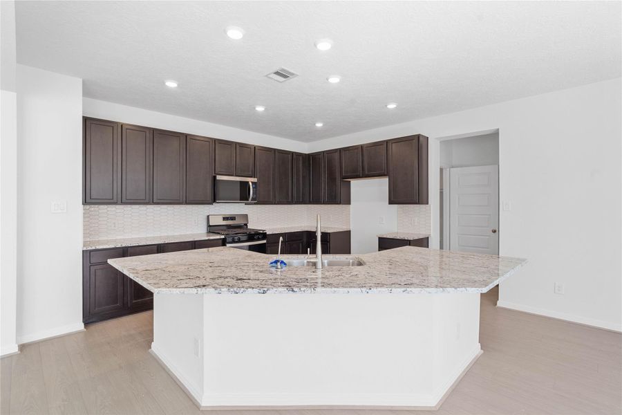 This spacious kitchen has it all—ample storage, generous counter space, and a layout that truly makes it the heart of the home