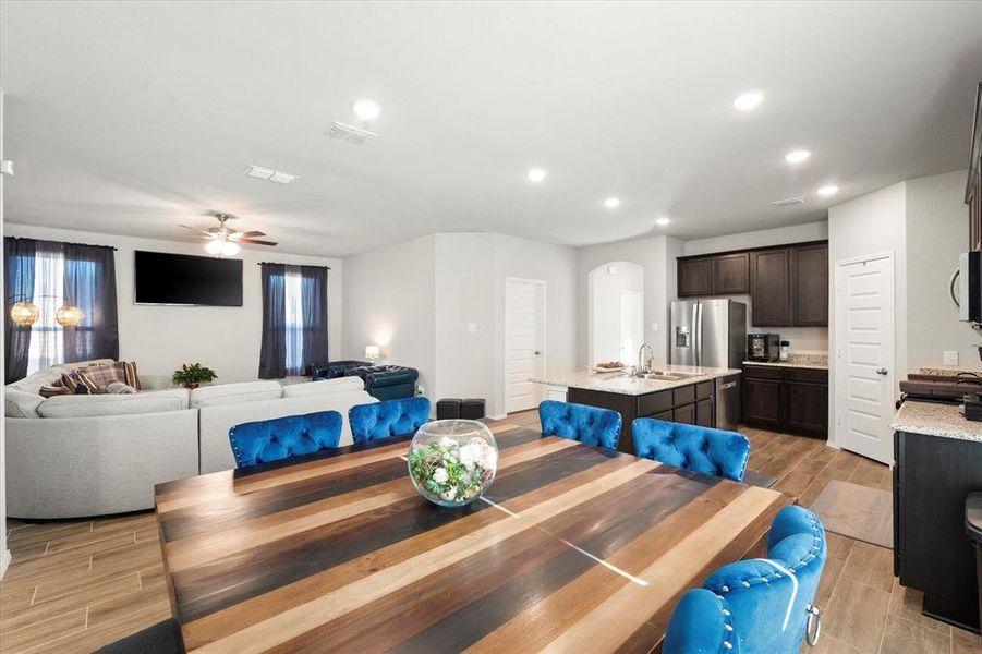 Dining space with ceiling fan, light hardwood / wood-style floors, and sink