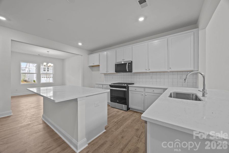 Kitchen with lots of storage, quartz counters and gas range