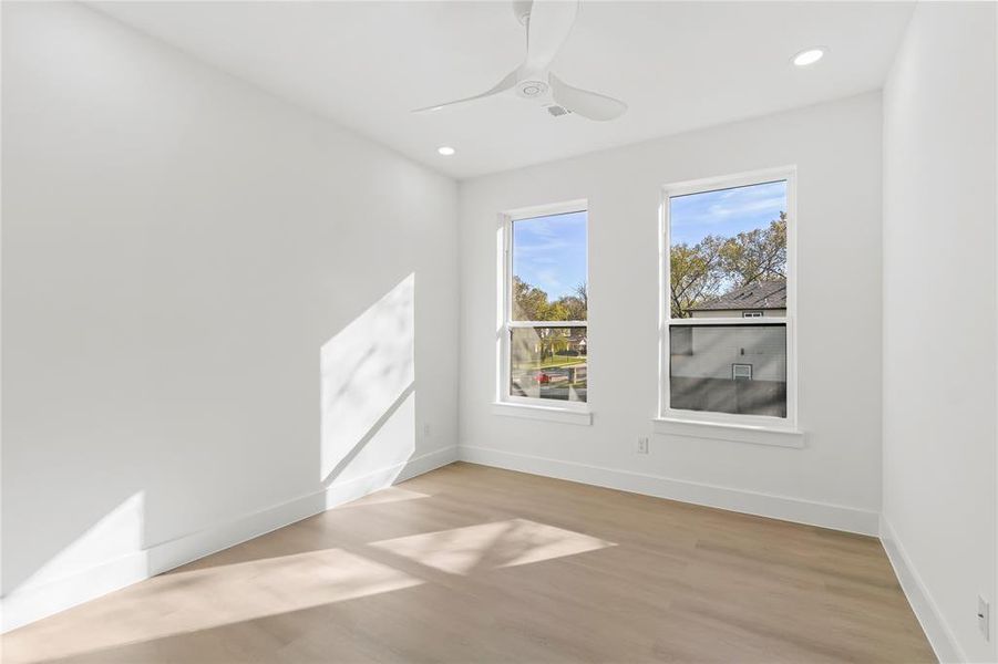 Spare room with light wood finished floors, ceiling fan, and recessed lighting