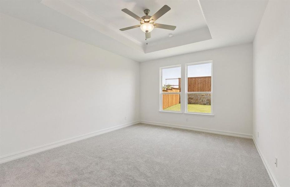 Spacious owner's suite highlighted by large windows and an exquisite tray ceiling  *Real home pictured