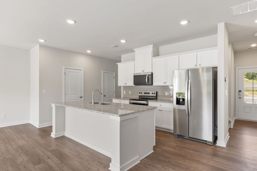 A kitchen with white cabinets.