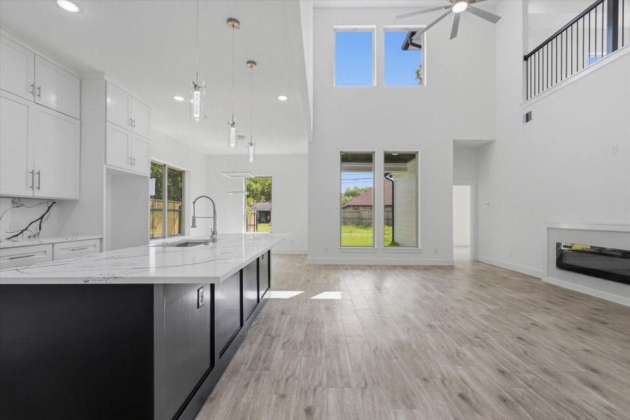 The great room makes a statement — soaring 21-foot ceilings and an open-concept layout create an inviting space for entertaining and everyday living alike. A 10-foot island anchors the kitchen, complemented by neutral tones throughout for a timeless feel. The great room makes a statement — soaring 21-foot ceilings and an open-concept layout create an inviting space for entertaining and everyday living alike. A 10-foot island anchors the kitchen, complemented by neutral tones throughout for a timeless feel.