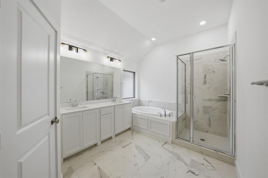 Full bathroom with a marble finish shower, double vanity, vaulted ceiling, a garden tub, and light marble finish floors