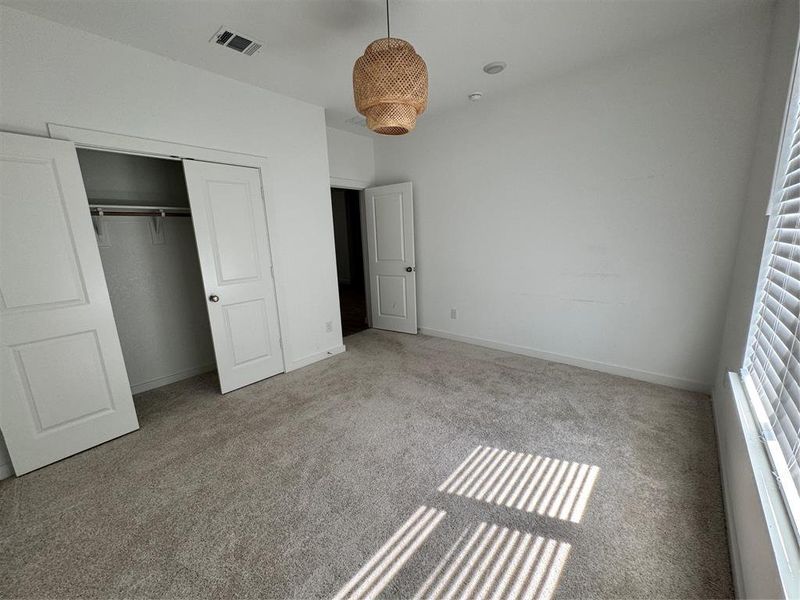 Bedroom featuring carpet and a closet Bedroom featuring carpet and a closet