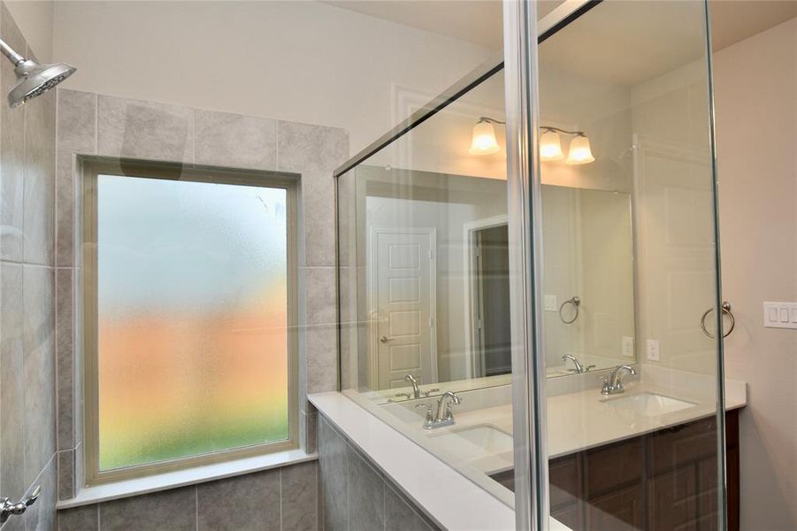 Bathroom with double vanity and healthy amount of natural light