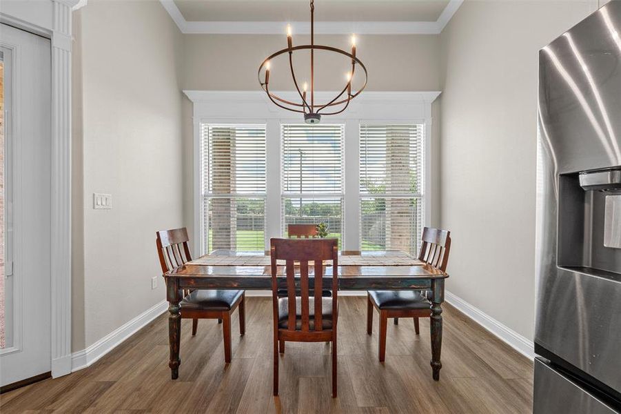 Dining area with luxury vinyl plank flooring and large windows overlooking the backyard. Dining area with luxury vinyl plank flooring and large windows overlooking the backyard.