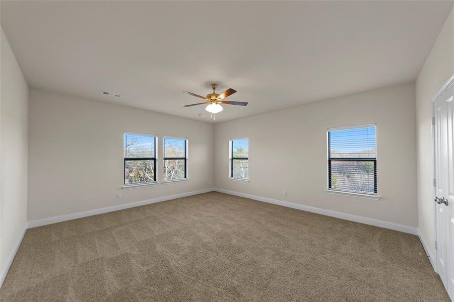 Unfurnished room featuring light colored carpet and ceiling fan