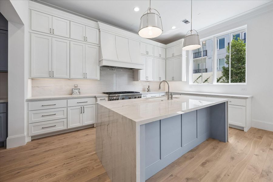 Kitchen features custom Benedettini cabinetry throughout, including upgraded decorative hood.