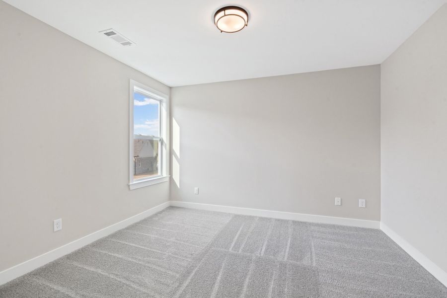 Empty room with light carpet and baseboards