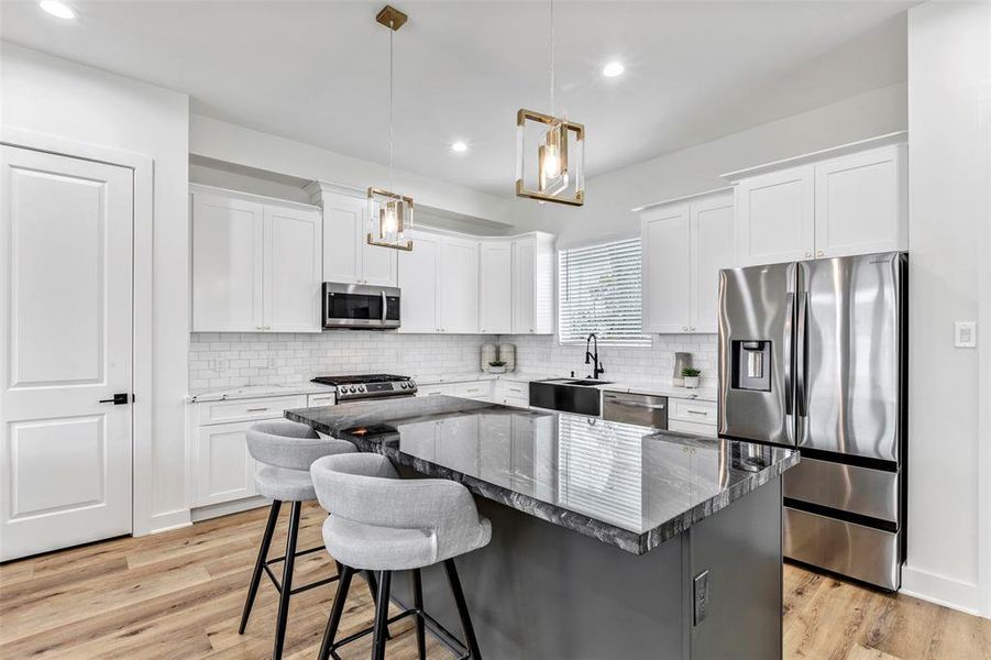 The gourmet kitchen is a chef's dream with stainless steel appliances, a gas range, quartz counters, and 100% natural quartz island.