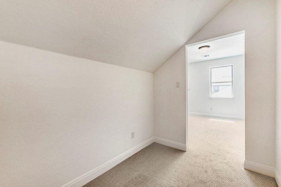 Bonus room featuring light carpet and lofted ceiling Bonus room featuring light carpet and lofted ceiling