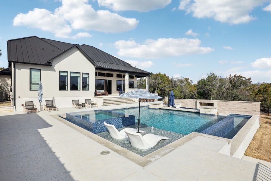 The backyard rivals high-end resorts with a custom heated pool featuring a graduated entry.