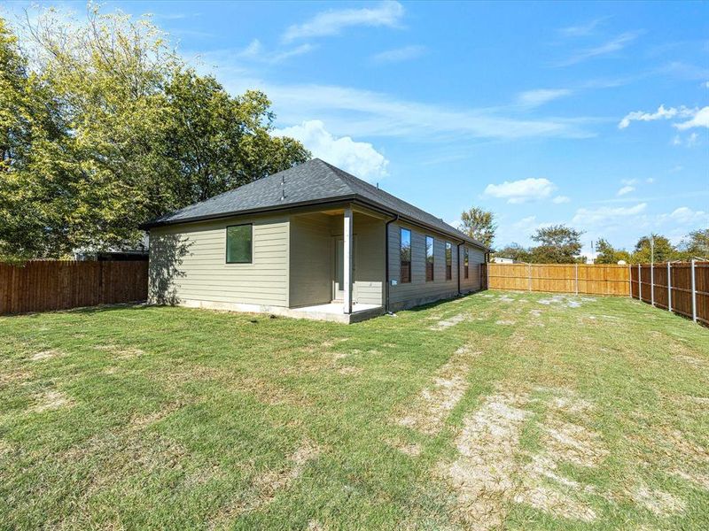 Rear view of house featuring a fenced backyard and a patio