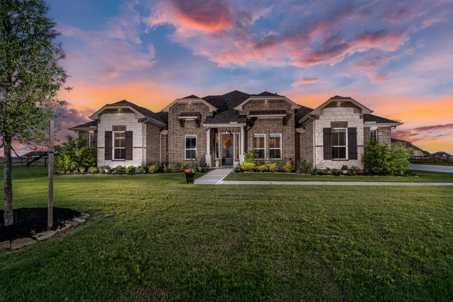 This stunning brick and stone elevation is both elegant and timeless with gorgeous downlights that illuminate this  home beautifully.