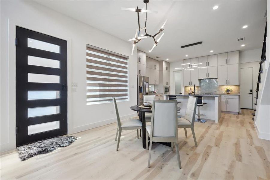 Dining room with light hardwood / wood-style flooring and a chandelier