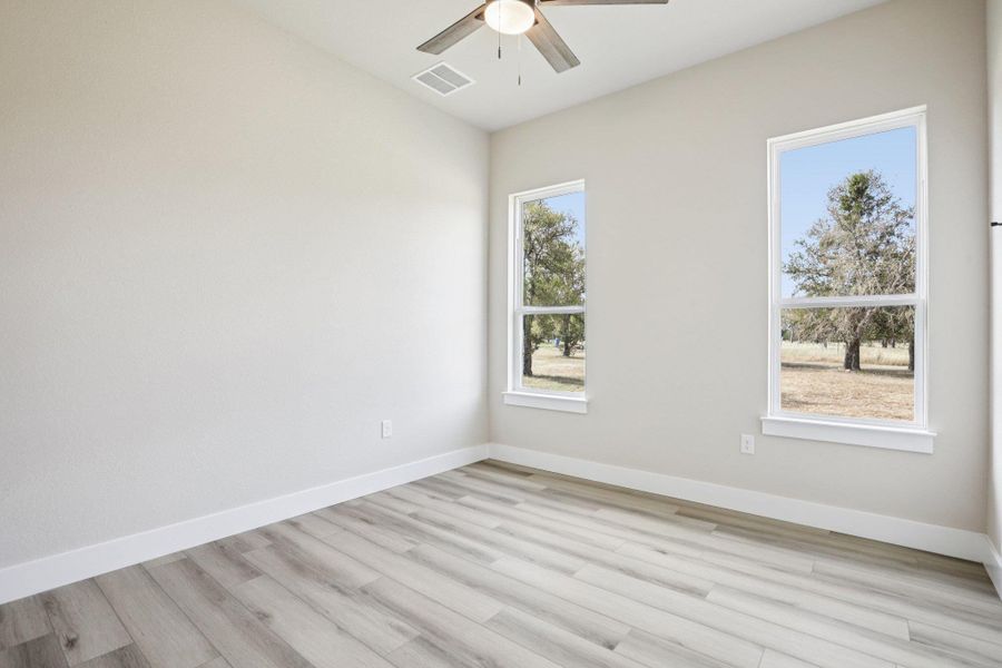 Unfurnished room featuring light wood finished floors and a ceiling fan