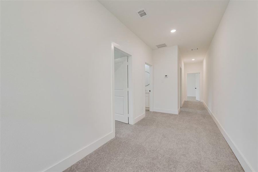 Hallway featuring light carpet, recessed lighting, visible vents, and baseboards