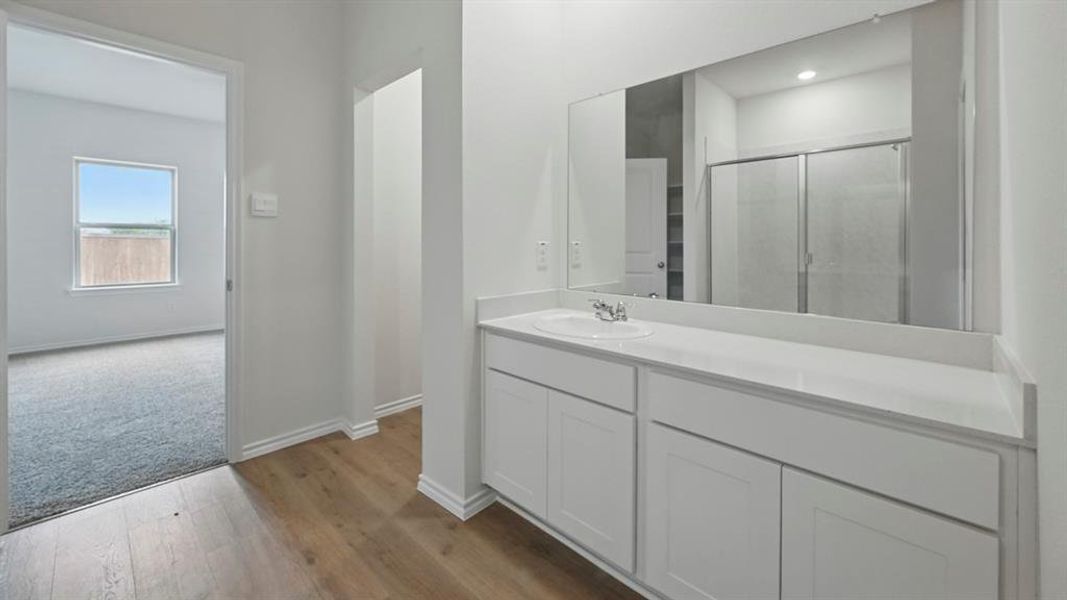 Bathroom featuring a shower stall, vanity, and dark wood finished floors