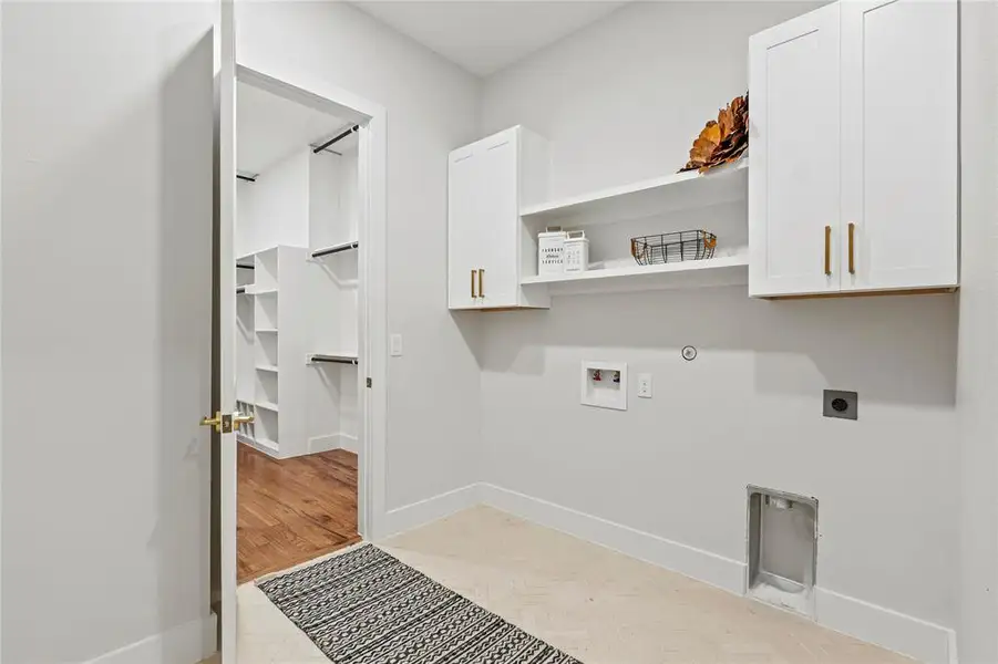 Laundry area featuring cabinet space, hookup for an electric dryer, washer hookup, and gas dryer hookup Laundry area featuring cabinet space, hookup for an electric dryer, washer hookup, and gas dryer hookup