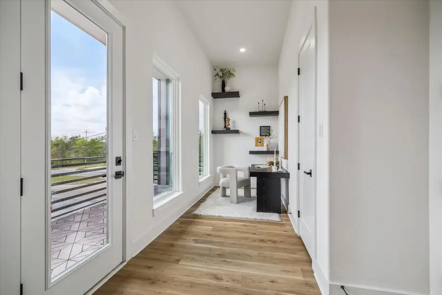 A view of your private space and balcony off of the primary suite! This space is ready for your books or decor to be place on the floating shelves