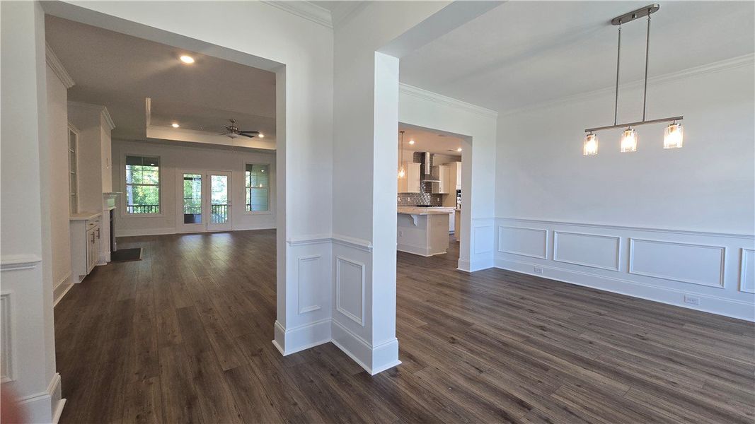 An open floorplan unveils elegant wainscoting and